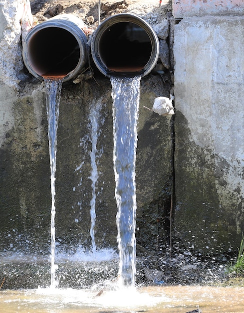 Foto l'acqua sporca scorre da due tubi