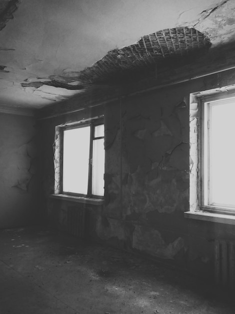 Dirty windows and old shabby ceiling and walls Interior of an old abandoned house