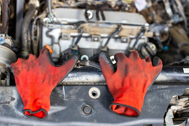 dirty work gloves under the hood of the car Car repair
