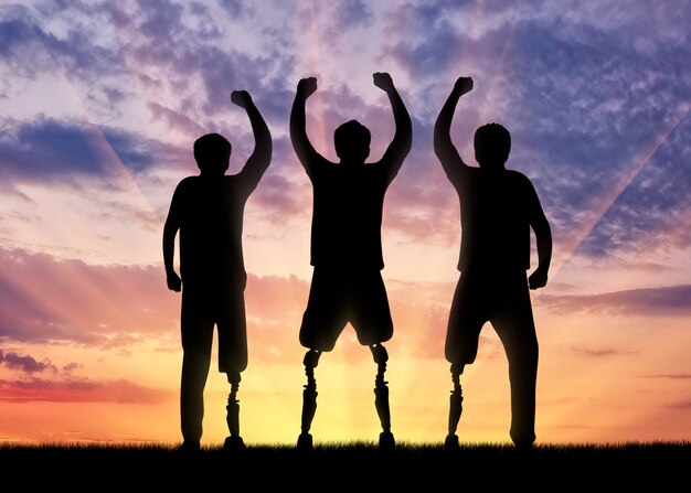 Disability concept. Happy disabled with a prosthetic leg standing on sunset background