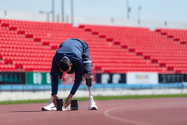 Disabled athletes prepare in starting position ready to run on stadium track