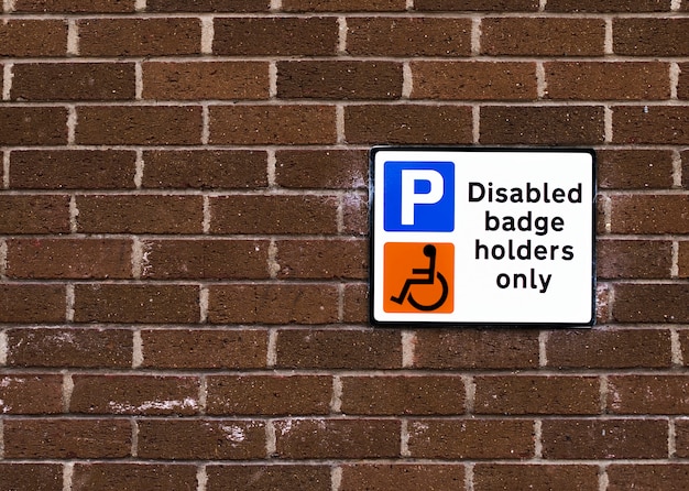 Disabled badge holders only sign on a brick wall