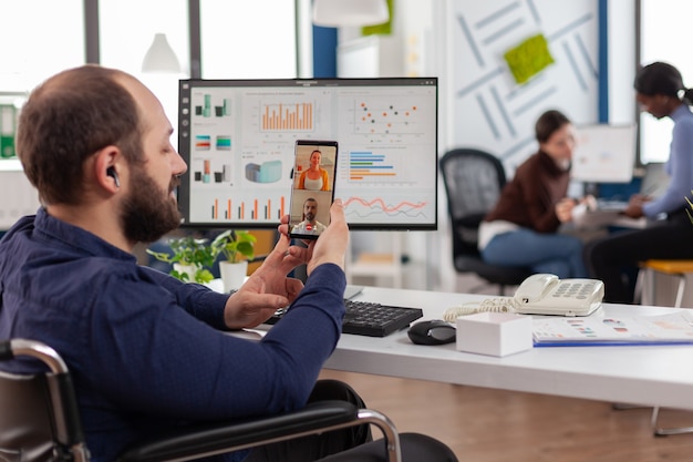 Disabled businessman entrepreneur discussing with colleagues during video call