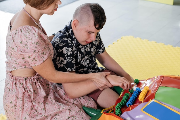 Photo disabled child doing sensory activity with toys rehabilitation