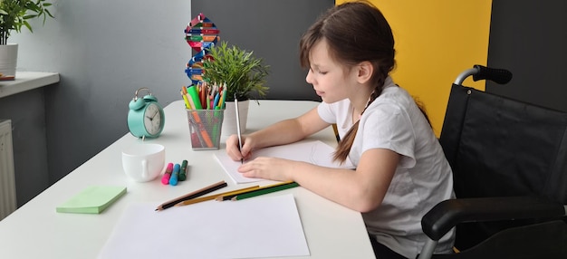 Фото Ребенок-инвалид в инвалидной коляске рисует произведения искусства и навыки развития мышц