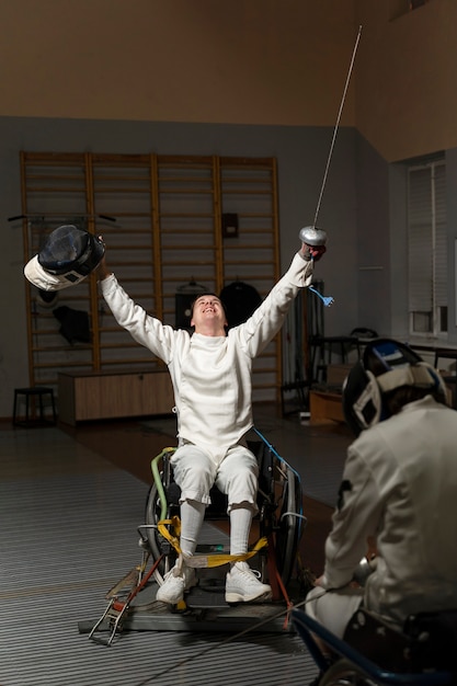 Disabled fencer in special equipment sitting in a wheelchair