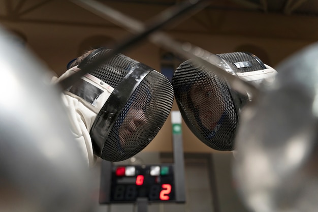 Photo disabled fencers in special equipment fighting from their wheelchairs