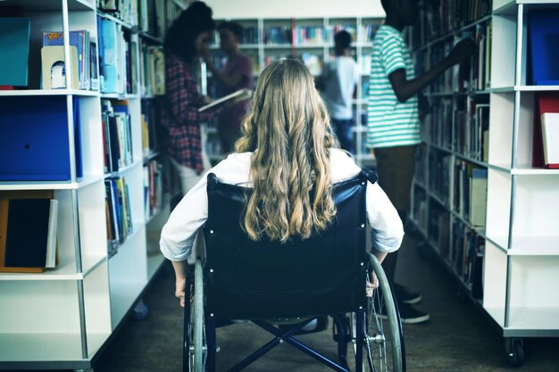 Disabled girl on wheelchair in library