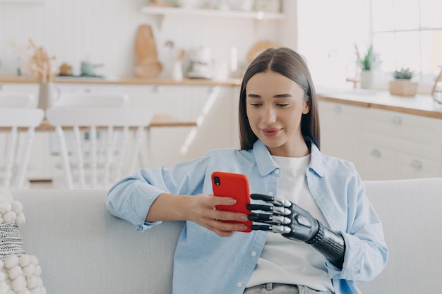 Disabled girl with bionic prosthetic arm holds smartphone Disability bionic prosthesis advertising