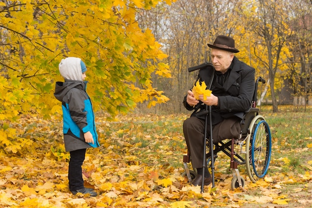 Disabled grandfather confined to a wheelchair playing with his cute little grandson