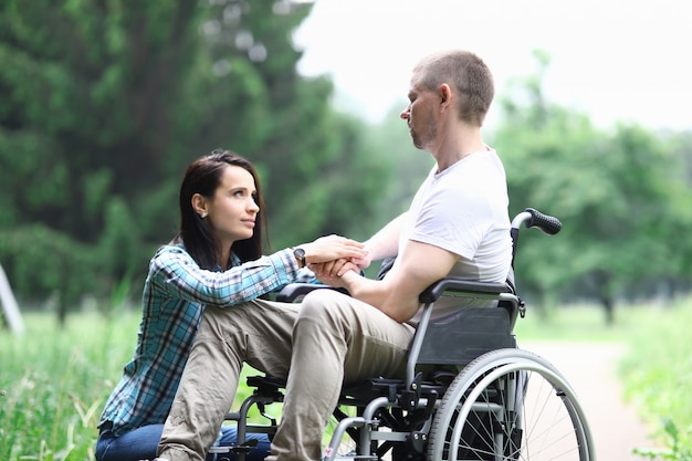 Disabled male veteran is sitting in wheelchair woman is sitting nearby