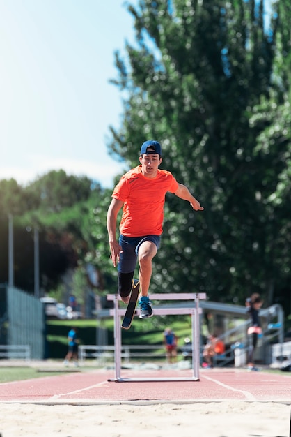 Disabled man athlete jumping with leg prosthesis. Paralympic Sport Concept.