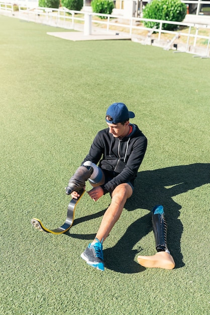 Disabled man athlete ready for training with leg prosthesis. Paralympic Sport Concept.