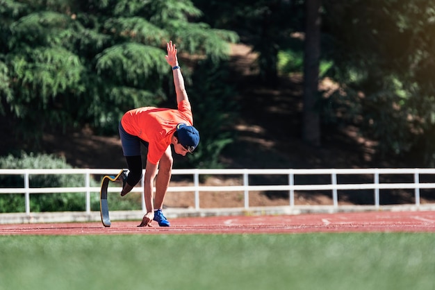 Disabled man athlete training with leg prosthesis. Paralympic Sport Concept.