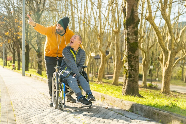 Disabled man and friend enjoying nature in a park