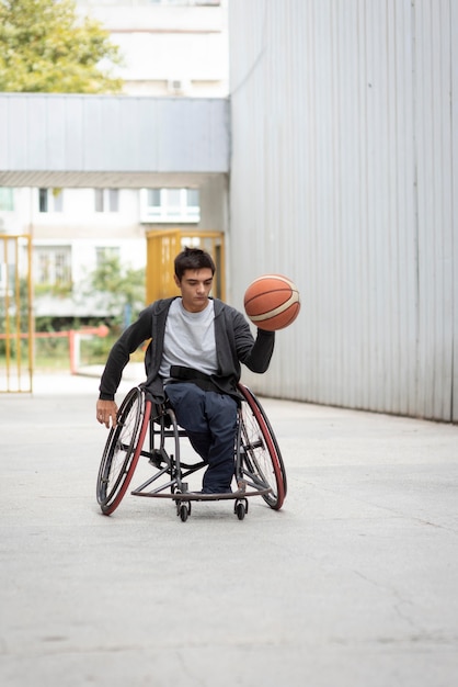 Foto uomo disabile che tiene il colpo completo di basket