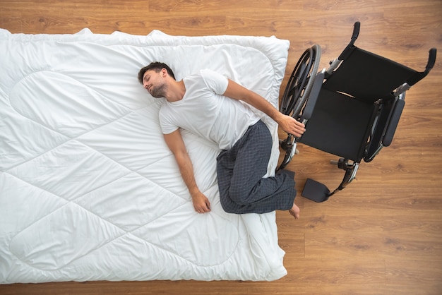 The disabled man laying on the bed. view from above