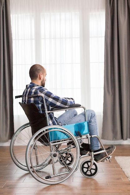 Photo disabled man sitting on wheelchair at home