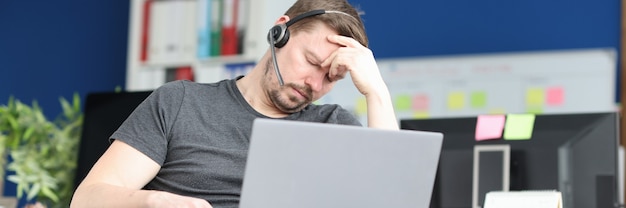 Disabled man sleeping in wheelchair with laptop on his lap resilience at work concept