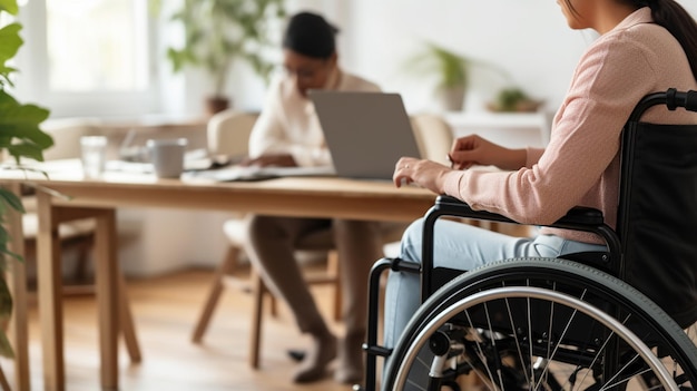 障害のある男性が車椅子に座って自宅で作業している間ラップトップを使用しています