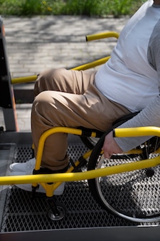 Uomo disabile in sedia a rotelle che entra nella vista laterale dell'auto