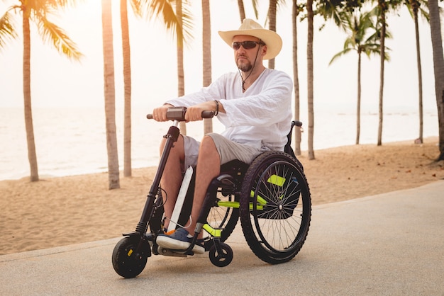 ビーチで電動スクーターで車椅子で無効になっている男