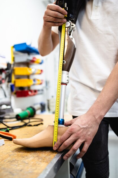 Disabled man working in amputee shop for production prosthetic extremity parts.