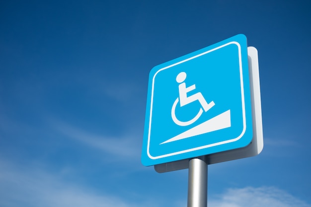 Photo disabled parking signage with blue sky.