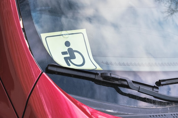 Disabled person driving sign on the windshield of a car identification symbol confirming the right of disabled car owners to benefits