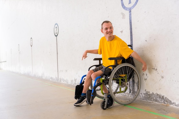 A disabled person in a wheelchair at a Basque pelota game fronton having fun