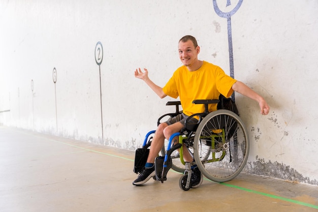 A disabled person in a wheelchair at a Basque pelota game fronton having fun