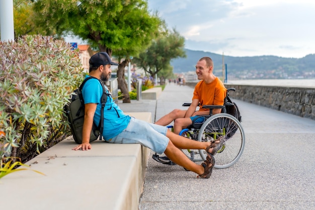 A disabled person in a wheelchair next to the beach with a friends