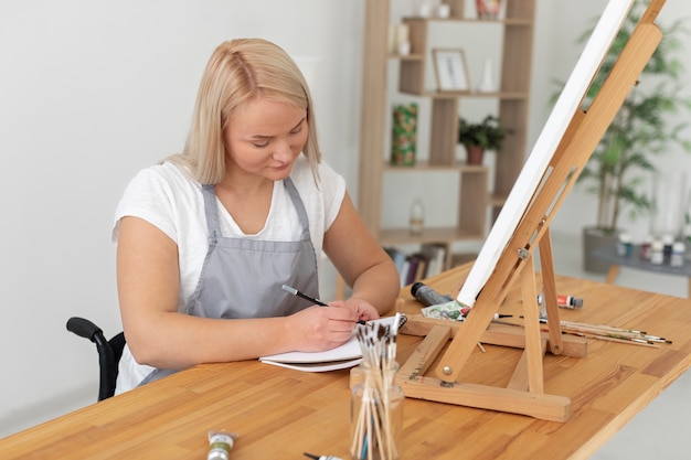 Photo disabled person in wheelchair painting