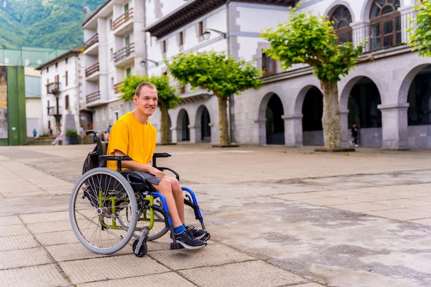 Un disabile in sedia a rotelle che cammina per la piazza del paese