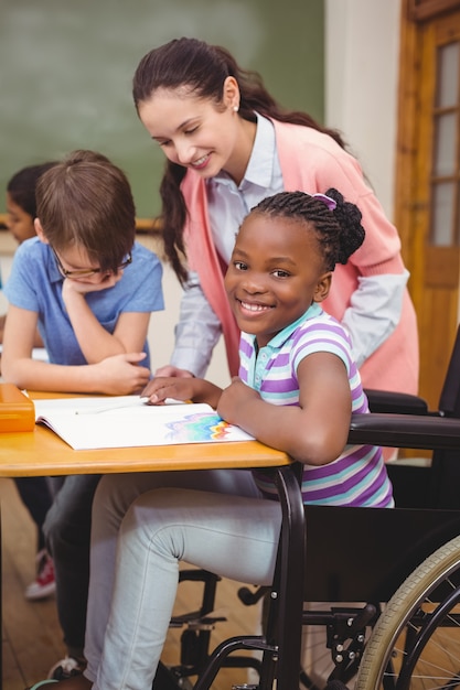 Disabled pupil smiling at camera in classroom