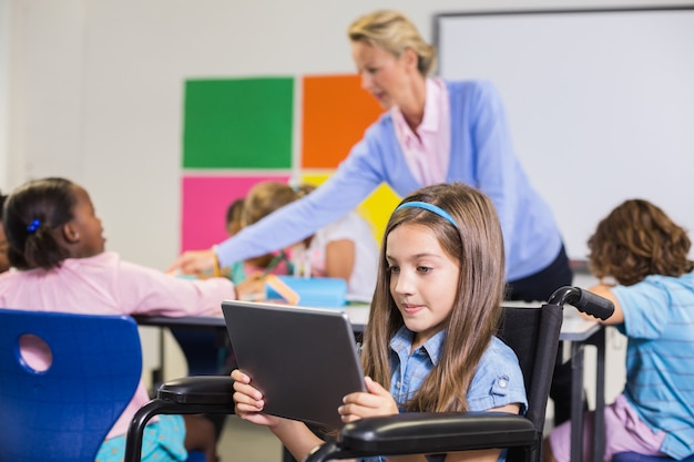 Disabled schoolgirl using digital tablet