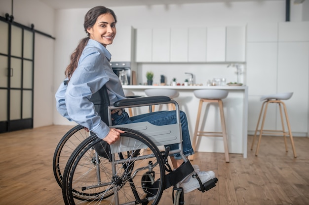 Disabilitato. una giovane donna sorridente seduta su una sedia a rotelle