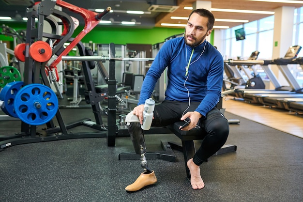 Disabled sportsman resting in gym