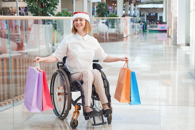 A disabled woman wearing a Santa hat, enjoying a Christmas sale in a shopping mall