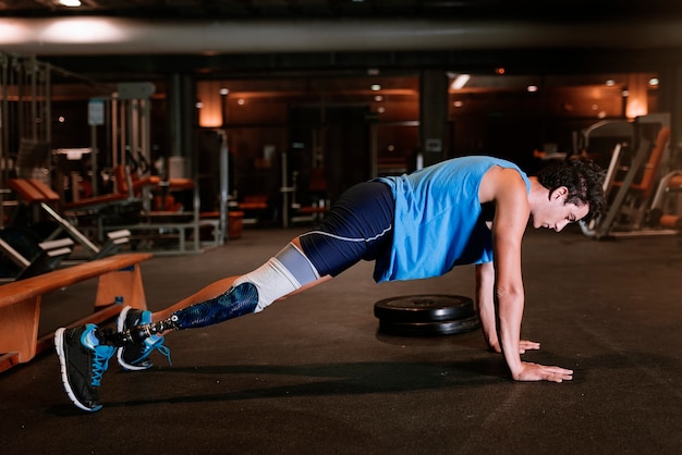 Disabled young man training in the gym. Disabled sportsman Concept.