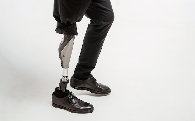 Disabled young man with prosthetic leg, artificial limb concept
