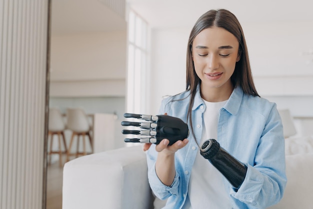 Disabled young woman is assembling bionic arm with hand Prosthesis is connecting in wrist joint