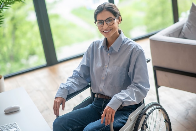 A disabled young woman looking contented and smiling nicely