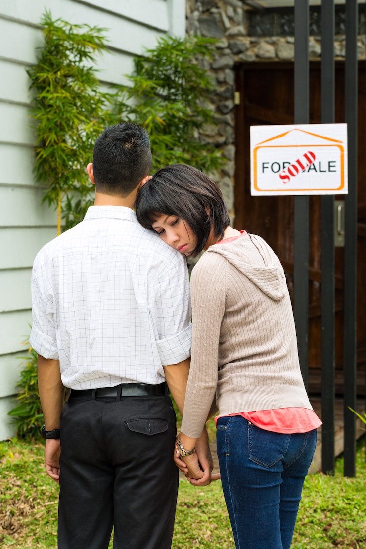 फोटो disappointed asian couple in front of a house