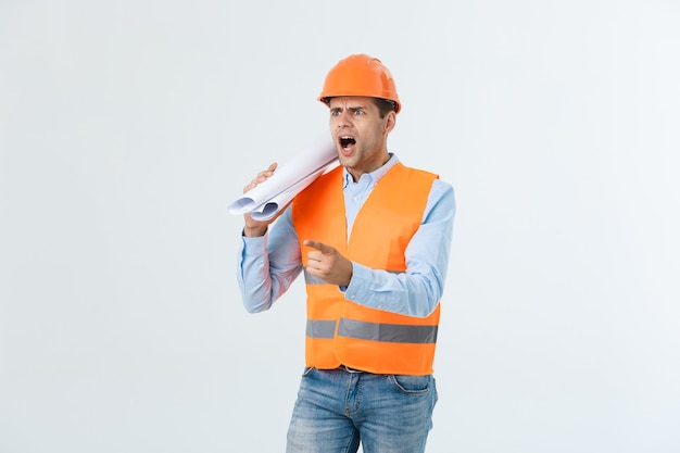 Разочарованный красивый инженер в оранжевом жилете и джинсах со шлемом, изолированным на белом фоне.