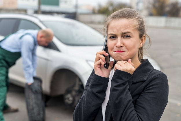 Разочарованная женщина в автосервисе звонит по телефону