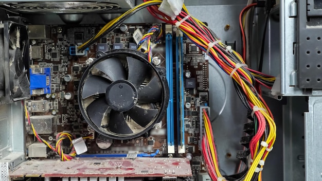 Disassembled dusty system unit. Man's hand scrolls a fan