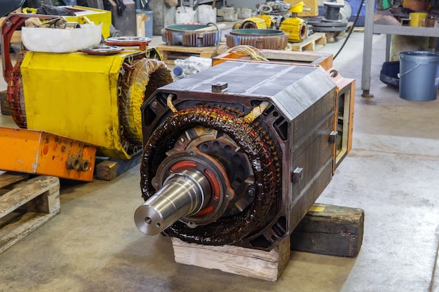 Disassembled large industrial electric motor in the repair process in the workshop