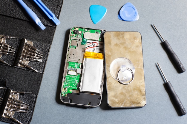 Disassembled mobile phone with repair tools