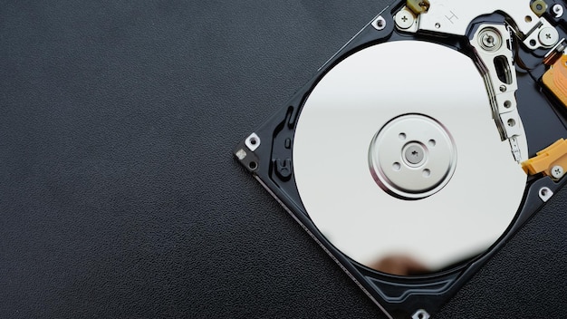 分解された開いたハードディスクドライブ コンピューターまたはラップトップの HDD が暗いマットな表面に置かれている コンピューターのハードウェアおよび機器 ハードディスクのデータストレージ